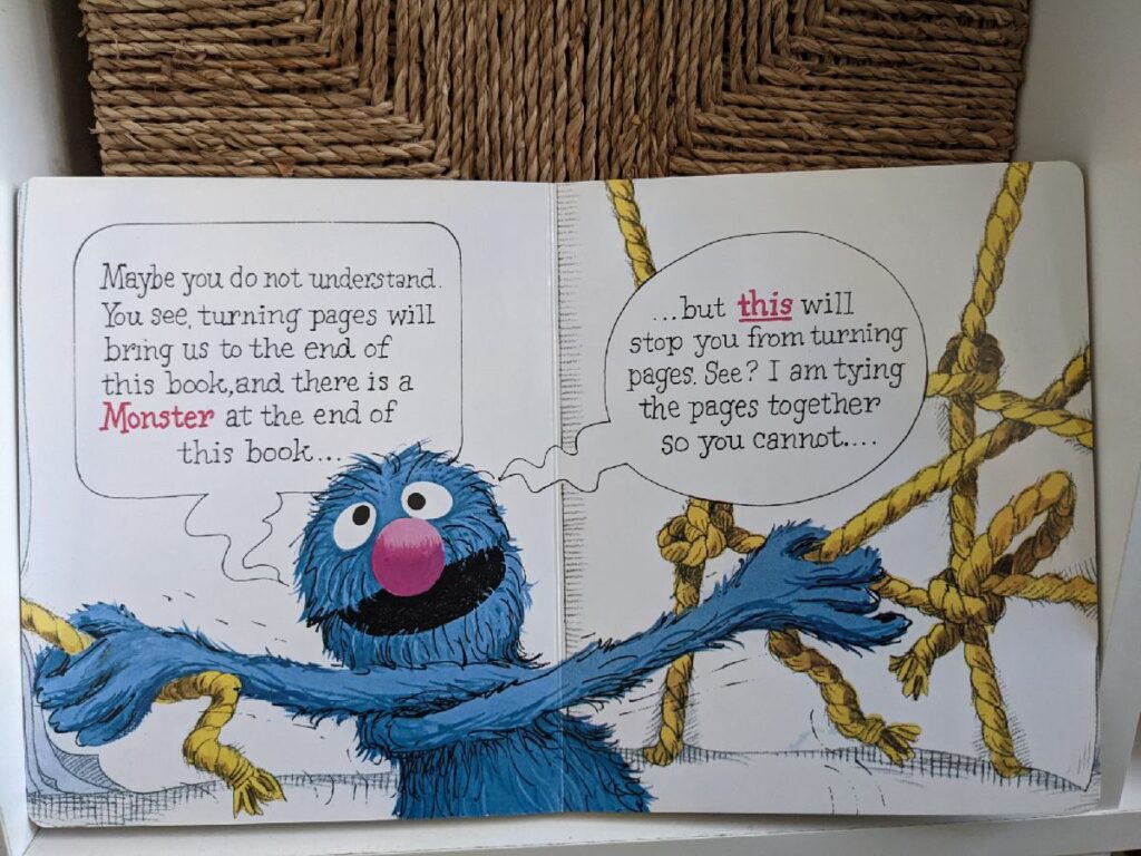 Grover tying the pages together so you cannot turn pages.