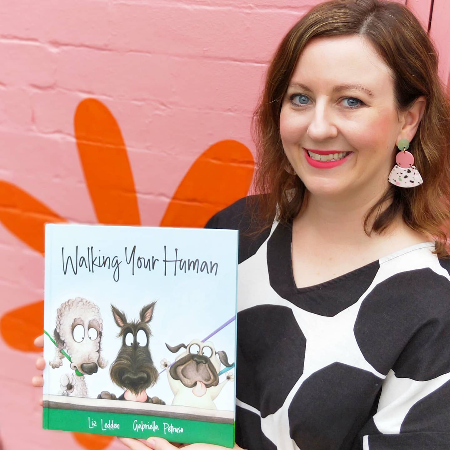Liz Ledden holding her picture book - Walking Your Human